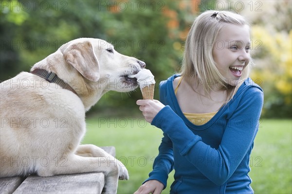 Dog eating girl’s ice cream cone. Date : 2008