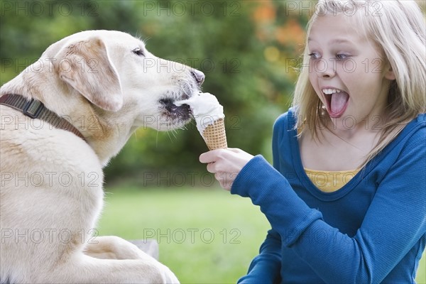 Dog eating girl’s ice cream cone. Date : 2008
