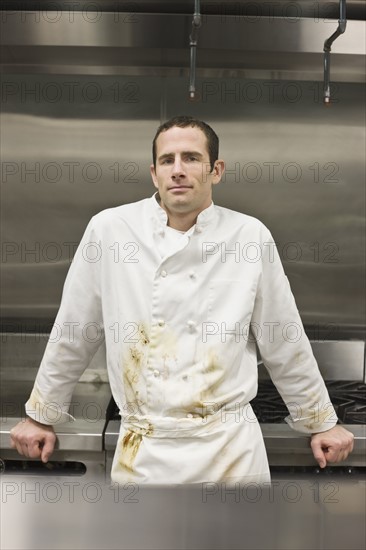 Dirty chef leaning against stove. Date : 2008