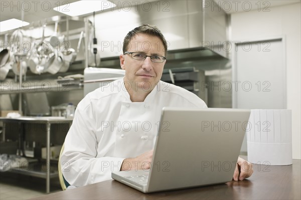 Chef working on laptop in kitchen. Date : 2008