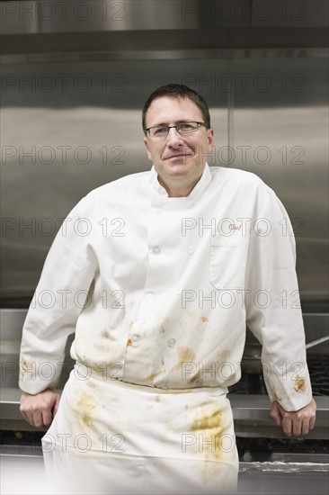 Dirty chef leaning against stove. Date : 2008