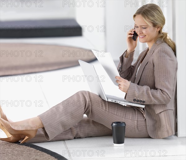 Businesswoman sitting on floor working. Date : 2008