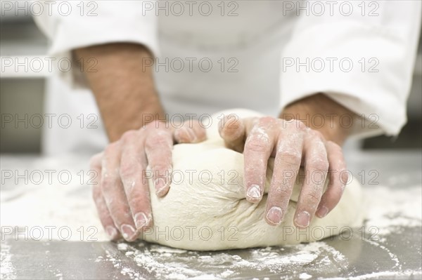 Baker kneading bread dough. Date : 2008