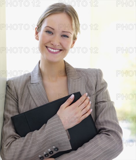 Portrait of businesswoman holding file. Date : 2008