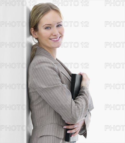 Businesswoman leaning against wall. Date : 2008