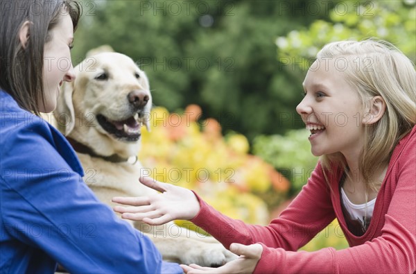 Girls sitting with dog in park. Date : 2008