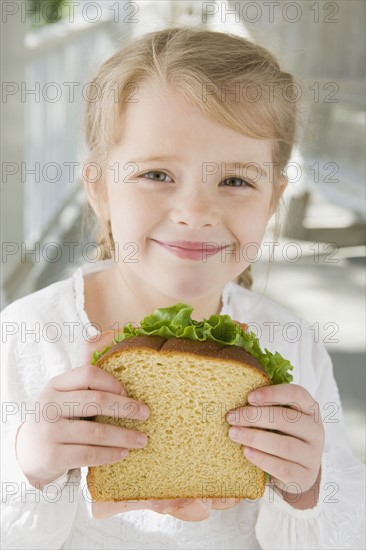 Girl eating sandwich on porch. Date : 2008