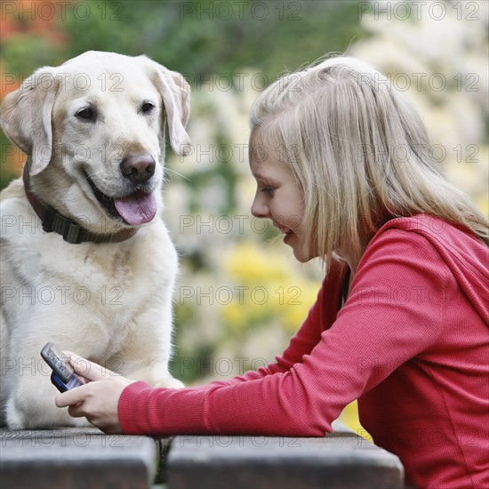 Dog watching girl use cell phone. Date : 2008