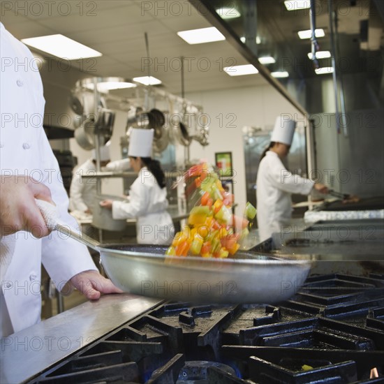 Chef tossing food in skillet. Date : 2008