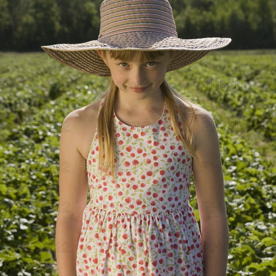 Girl standing in strawberry field. Date : 2008
