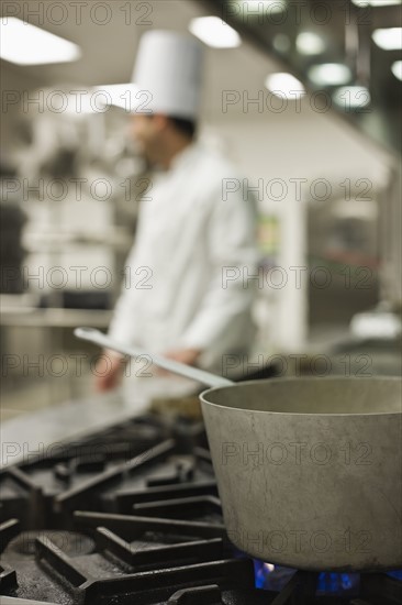 Chef and pot on stove. Date : 2008