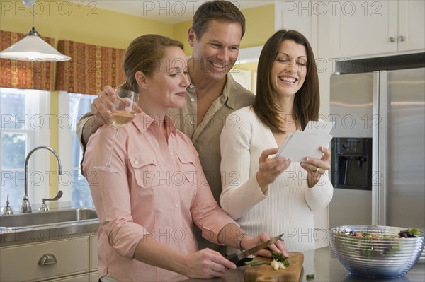 Friends looking at photographs at dinner party. Date : 2008