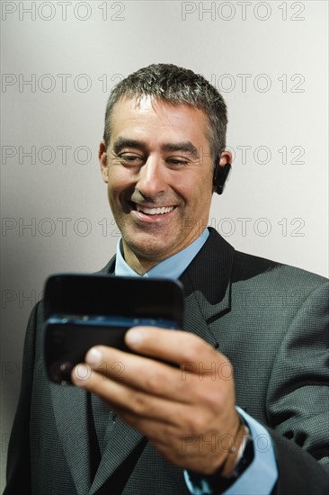 Businessman using cell phone and hands-free device. Date : 2008