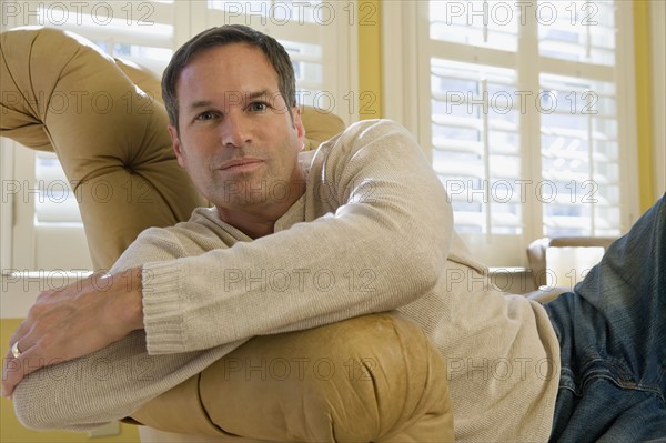 Man relaxing in arm chair. Date : 2008