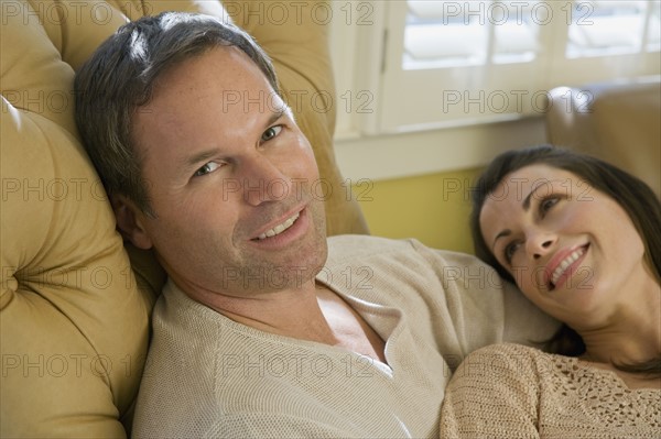 Couple relaxing in livingroom. Date : 2008