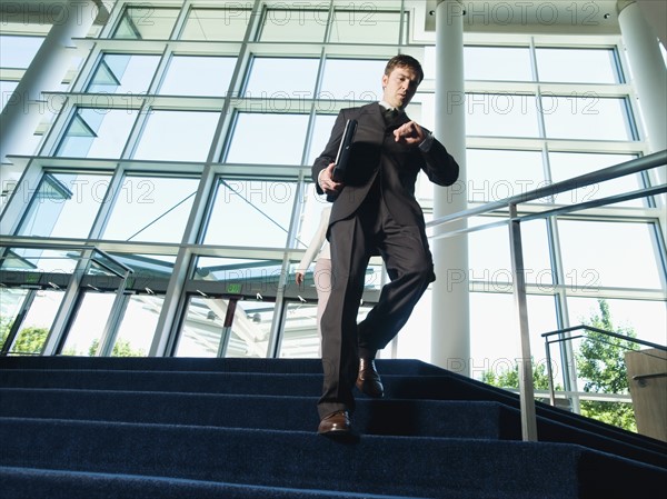 Businessman descending office building stairs. Date : 2008