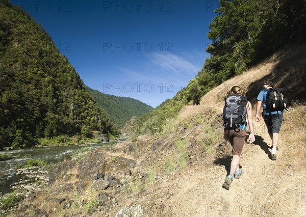 Hikers walking on riverside trail. Date : 2008