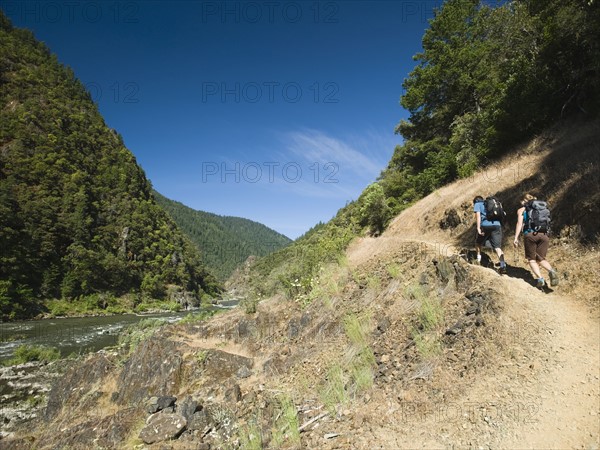 Hikers walking on riverside trail. Date : 2008