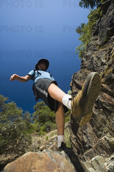 Hiker stepping down rocky trail. Date : 2008