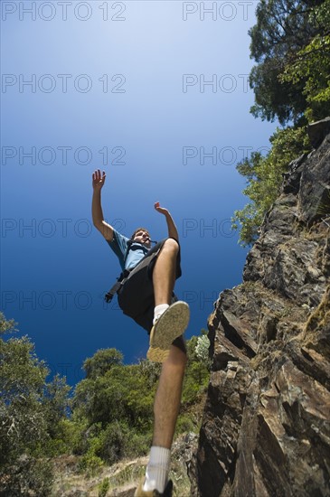Hiker jumping down rocky trail. Date : 2008