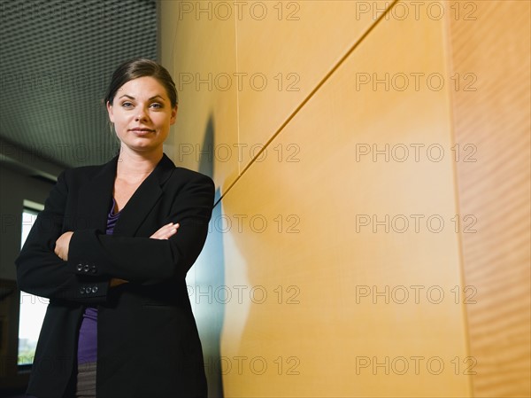 Confident businesswoman standing in office corridor. Date : 2008