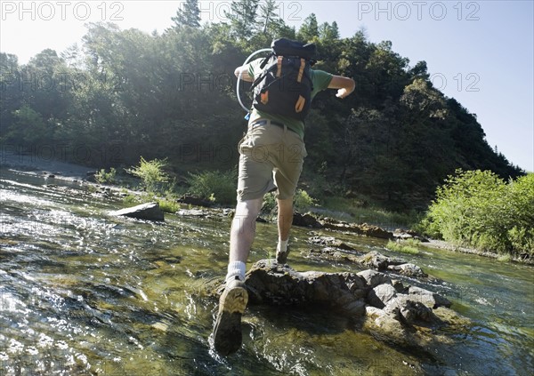 Man jumping across river on rocks. Date : 2008