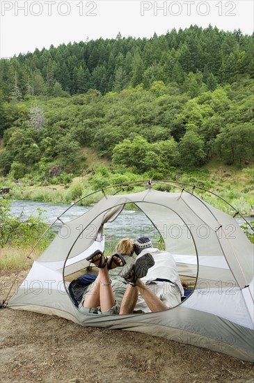 Couple relaxing in tent. Date : 2008