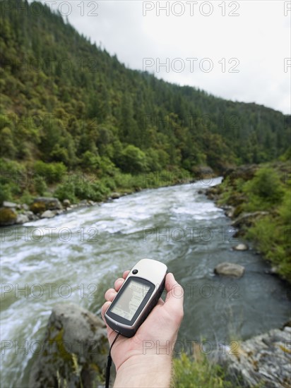 Man holding gps unit by river. Date : 2008