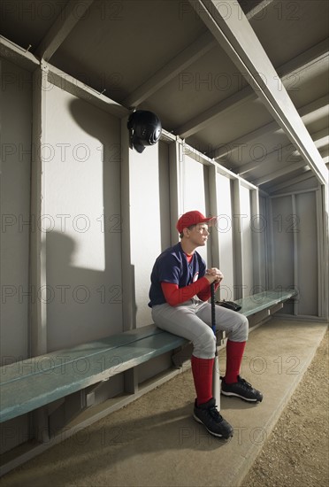 Serious baseball player sitting in dugout. Date : 2008