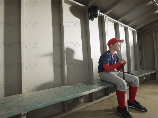 Serious baseball player sitting in dugout. Date : 2008