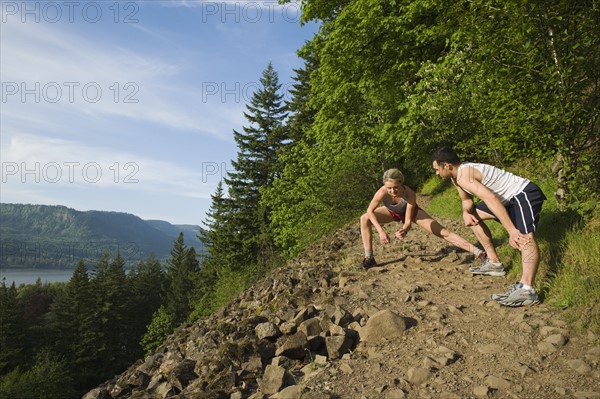 Runners stretching on rocky trail. Date : 2008