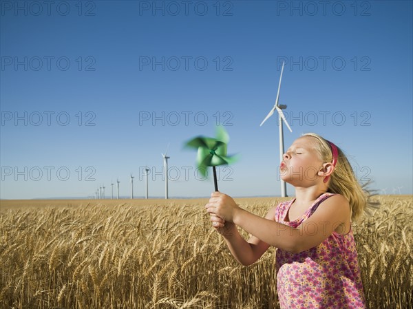 Girl holding pinwheel on wind farm. Date : 2008