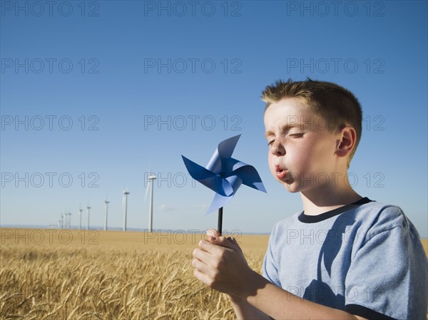 Boy holding pinwheel on wind farm. Date : 2008