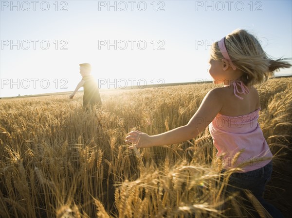 Children running through tall wheat field. Date : 2008
