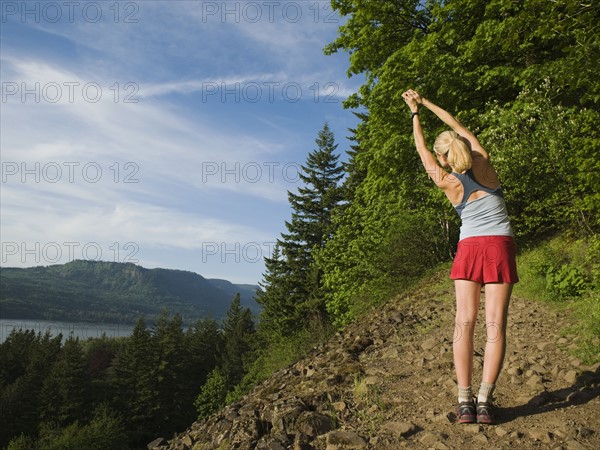 Runner stretching on rocky trail. Date : 2008