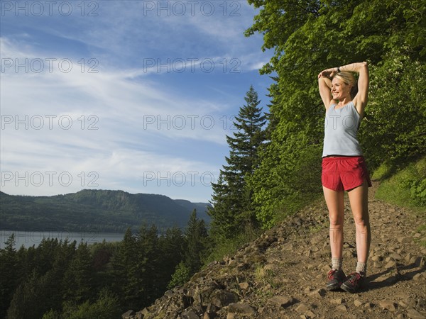 Runner stretching on rocky trail. Date : 2008