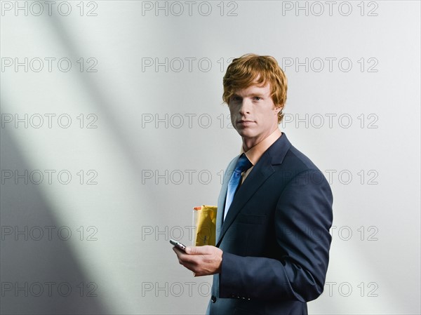 Businessman holding cell phone. Date : 2008