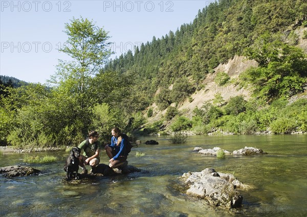 Hikers resting on rock in middle of river. Date : 2008