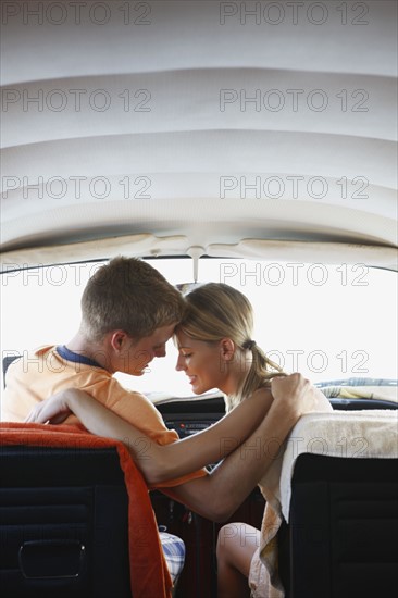 Young couple sitting in van on beach. Date : 2008