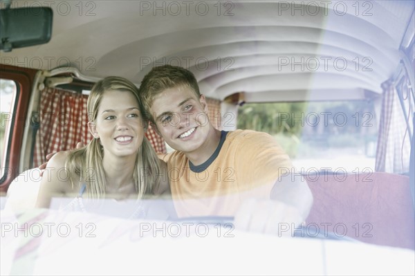 Young couple sitting in van on beach. Date : 2008