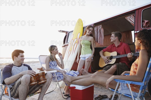 Friends socializing around van on beach. Date : 2008