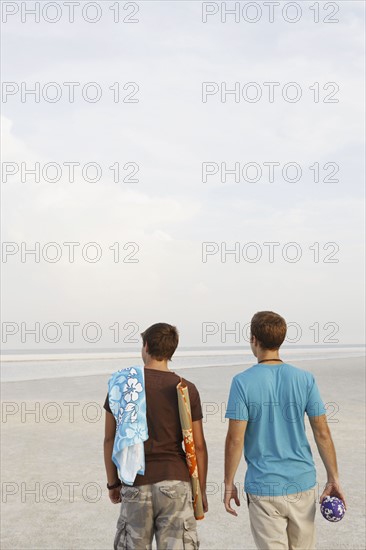 Young men walking on beach. Date : 2008
