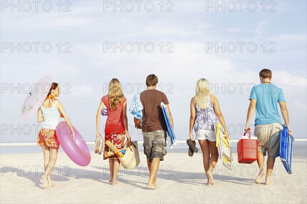 Friends walking with beach essentials. Date : 2008