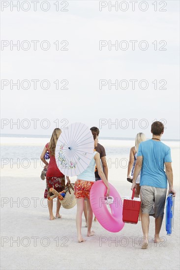 Friends walking with beach essentials. Date : 2008