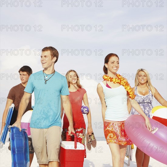 Friends walking with beach essentials. Date : 2008