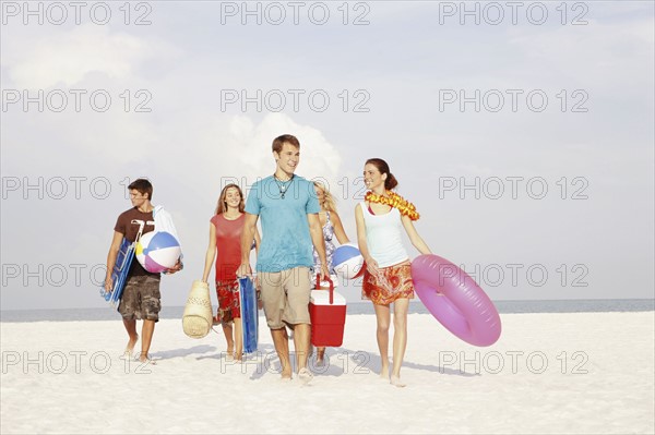 Friends walking with beach essentials. Date : 2008