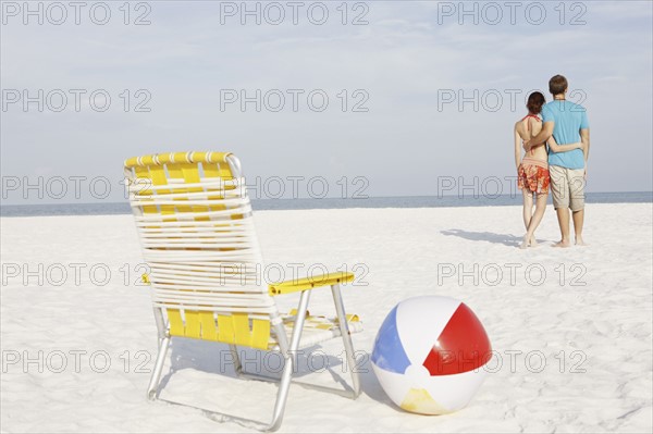 Young couple, chair and ball on beach. Date : 2008