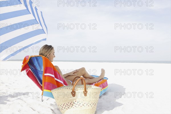 Teenage girl relaxing on beach. Date : 2008