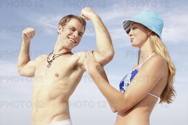Young man flexing muscles for girlfriend. Date : 2008