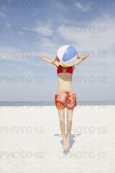 Young woman jumping with beach ball. Date : 2008